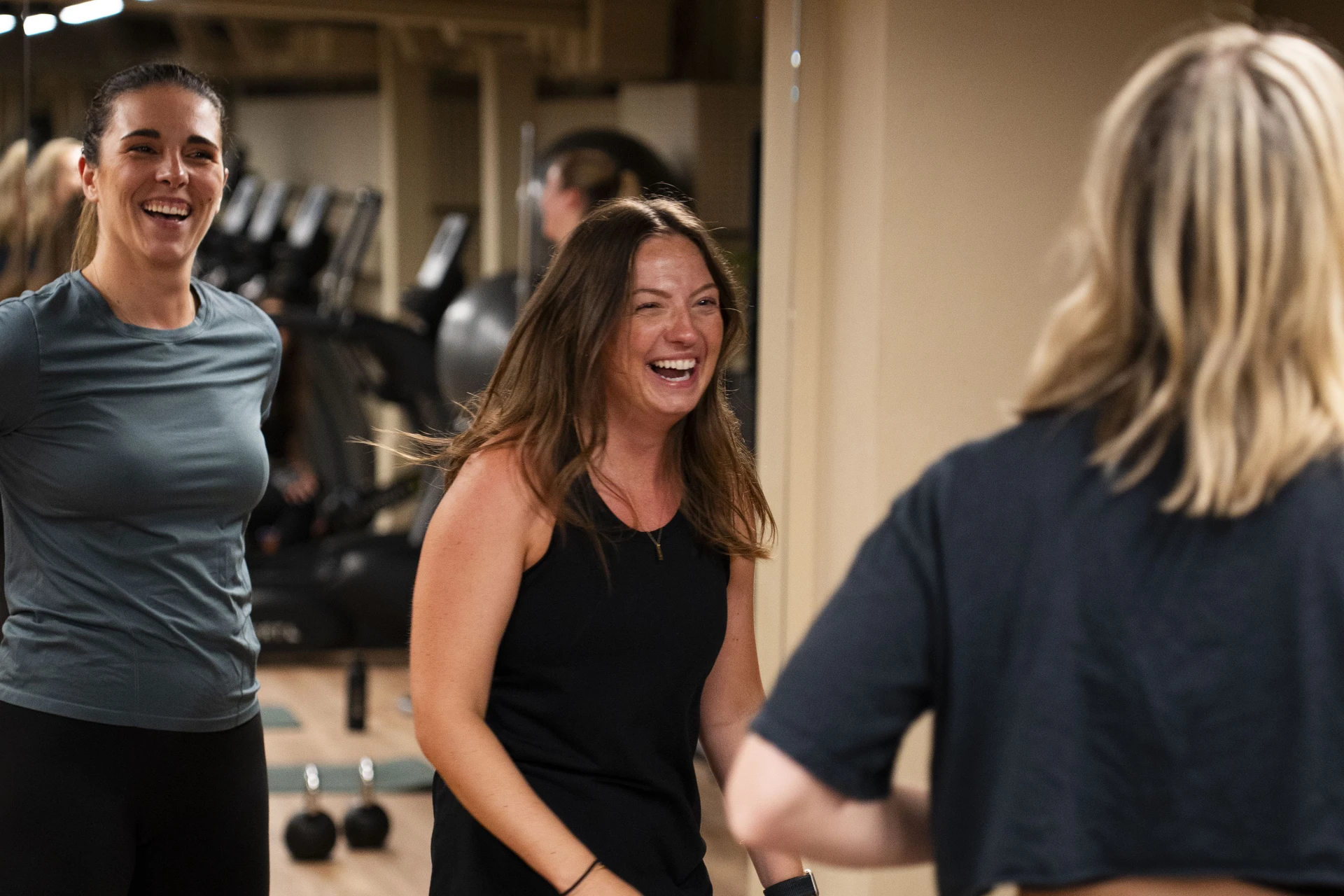 Three women laughing together during a small-group training session